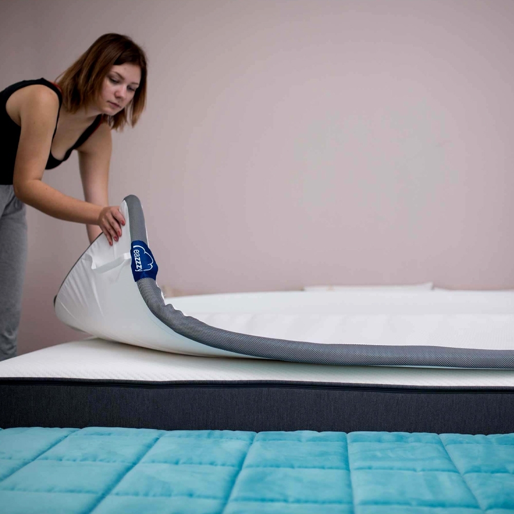 Genius eazzzy Topper Deluxe auf einem Bett im Schlafzimmer