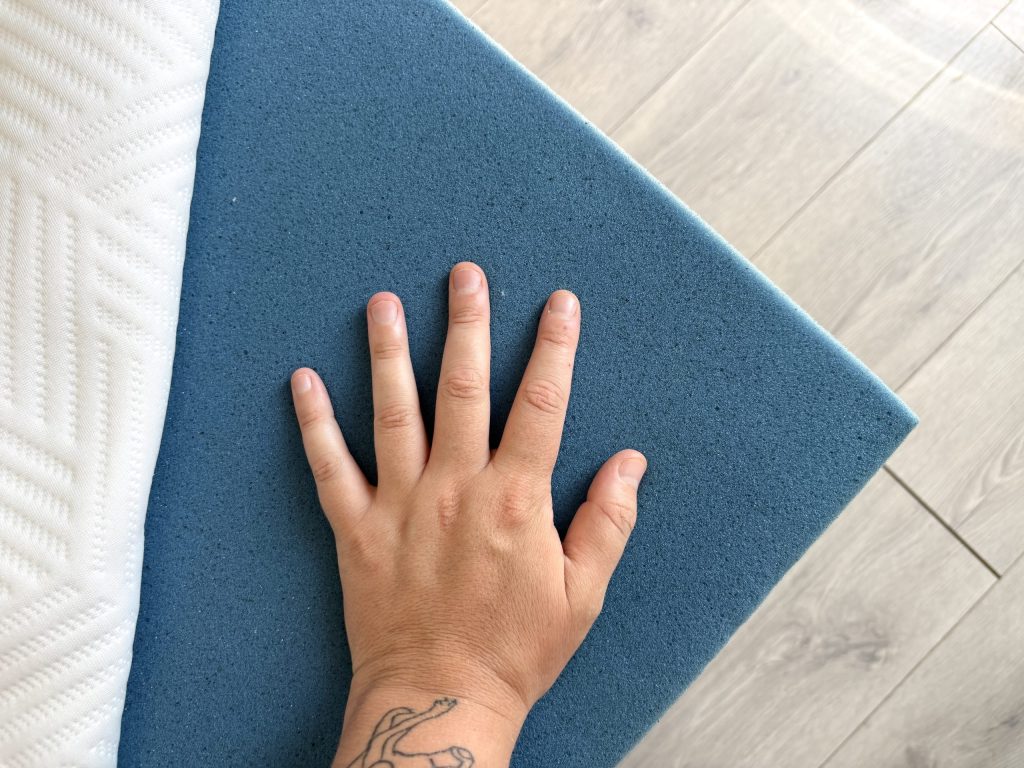 Hand auf der obersten Schaumschicht der Emma Original Pro bei geöffnetem Bezug