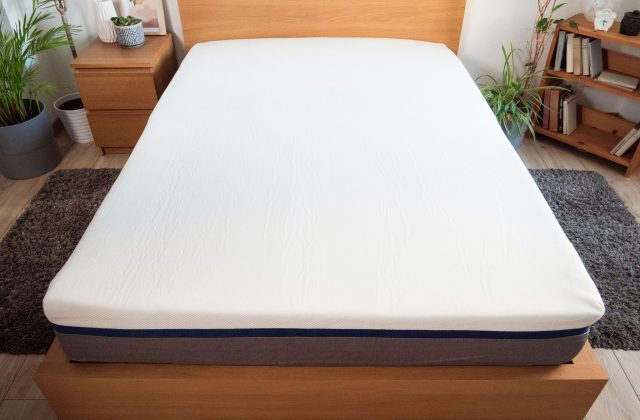 Doppelbett mit Matratze im Standardmaß auf einem Holzbettgestell