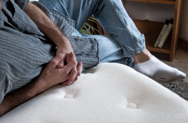 Person sitzt auf einer Matratze