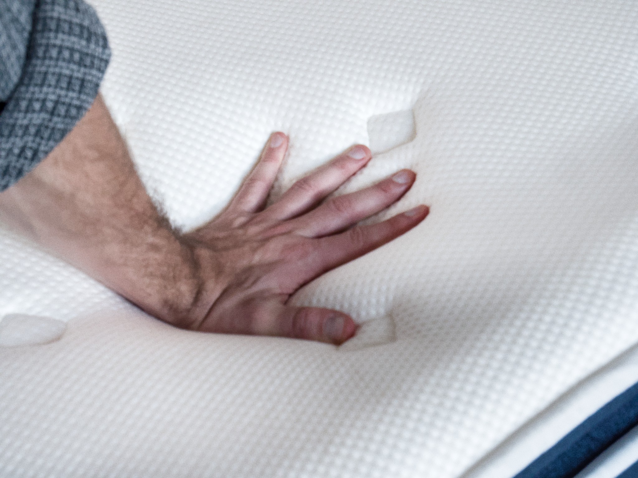 Hand auf dem Matratzenbezug