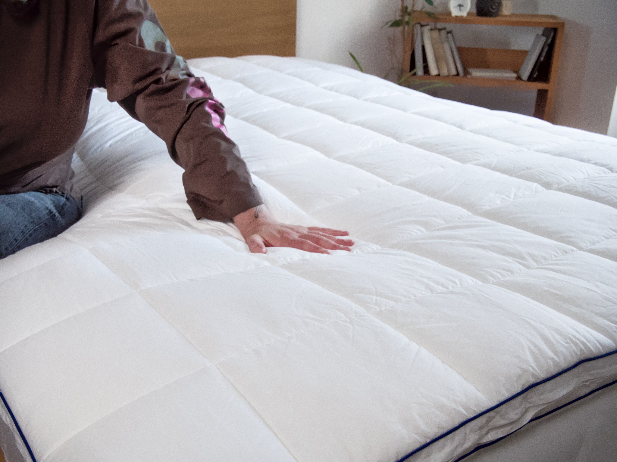 Person testet einen Topper mit der Hand