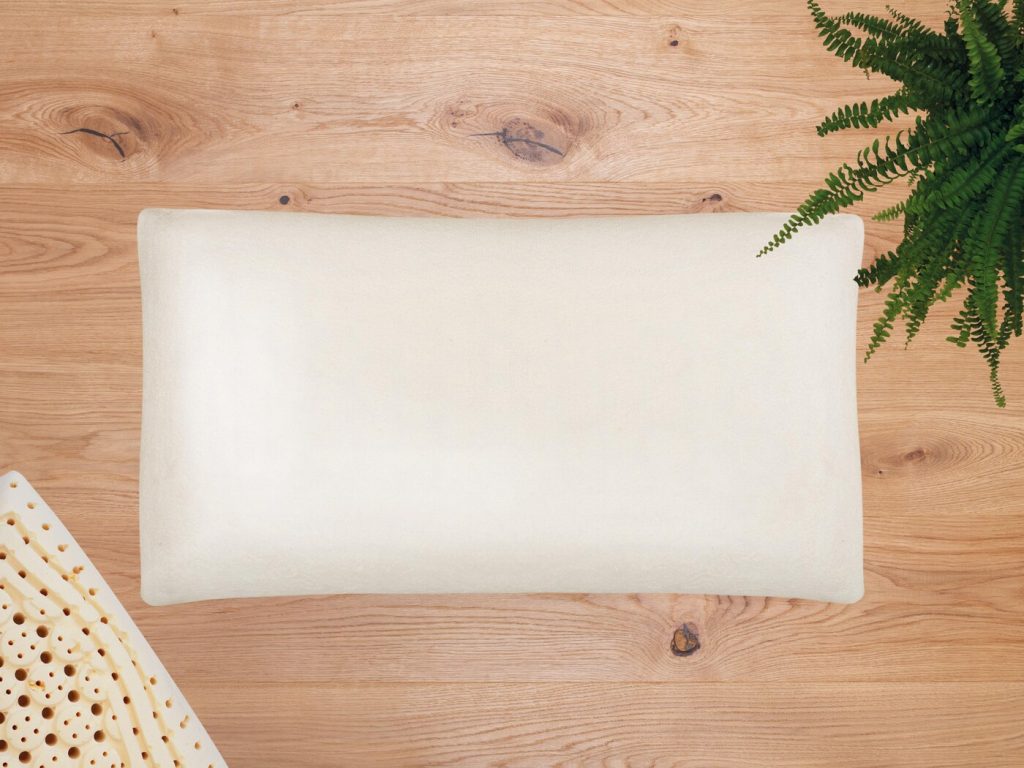 allnatura Nackenstützkissen Sana-Ergo mit Naturlatex-Muster auf Holzuntergrund