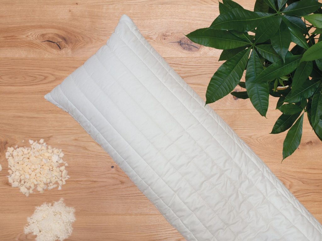 allnatura Seitenschläferkissen Lano mit Wollflocken und Latexflocken auf Holz