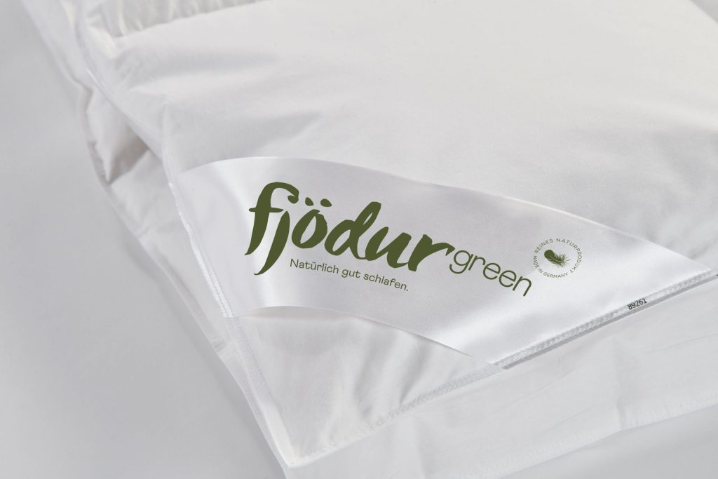 fjödur 3-Kammer-Kopfkissen Fleur – Nahaufnahme des Markenbands am Bezug