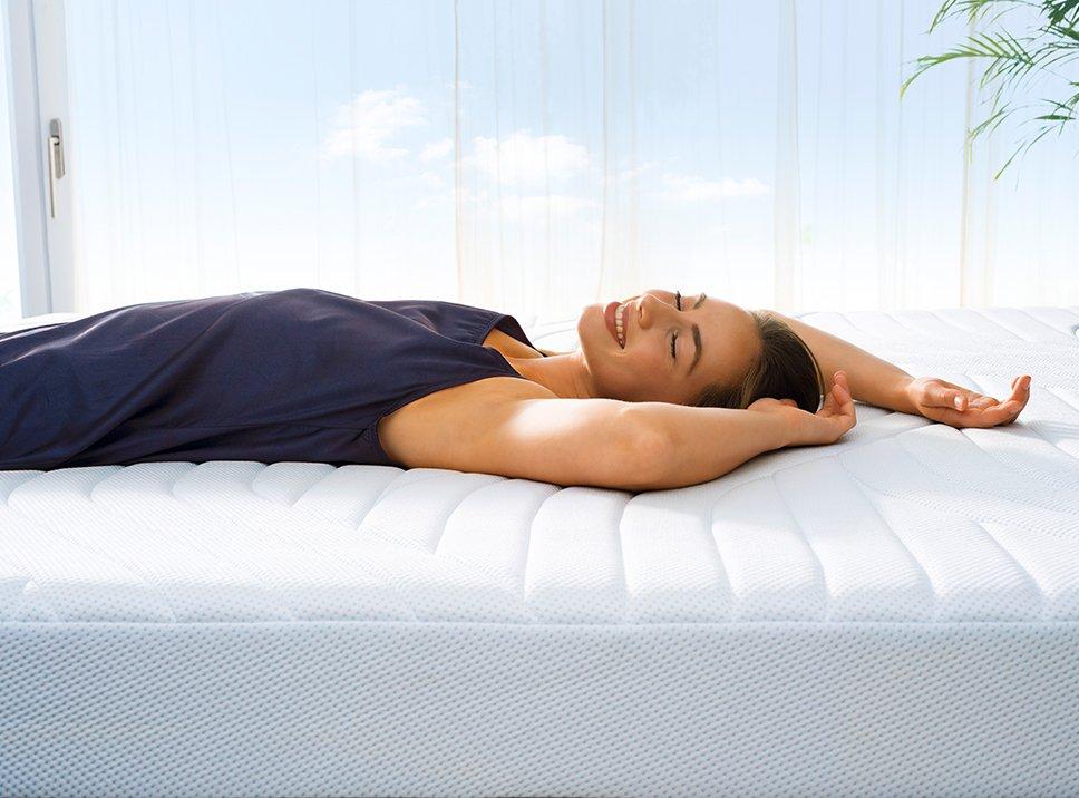 Frau liegt entspannt auf der TEMPUR PRO CoolQuilt Matratze