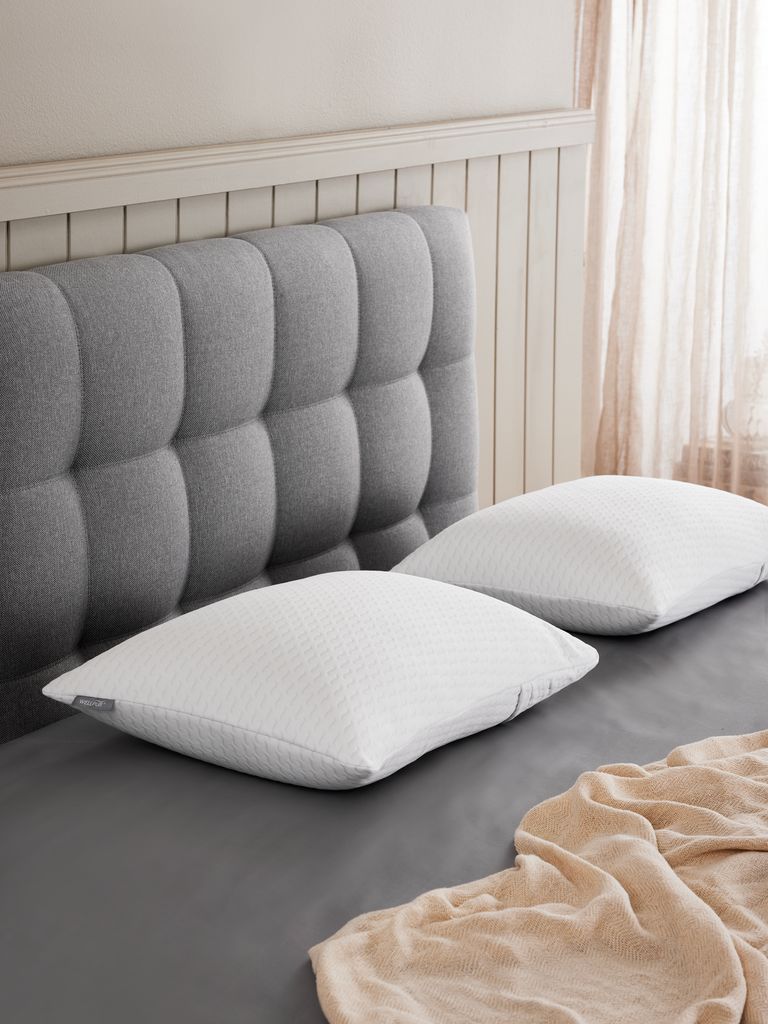 Zwei Wellpur STRYN Memoryschaum-Kissen auf einem Bett im Schlafzimmer