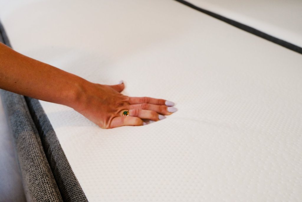 Hand drückt auf die Matratzenkante des ausgeklappten Emma Original Schlafsofas