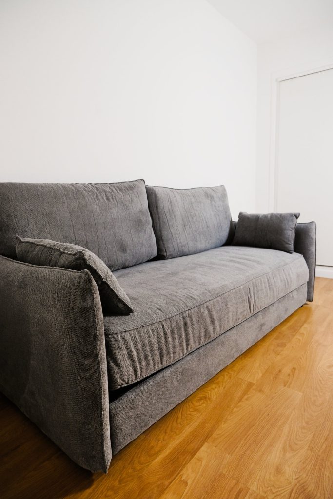 Emma Original Schlafsofa in Grau schräg von vorn im Wohnzimmer