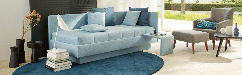 Joka Calma Einzelbett als Couch mit Ablage im Wohnraum