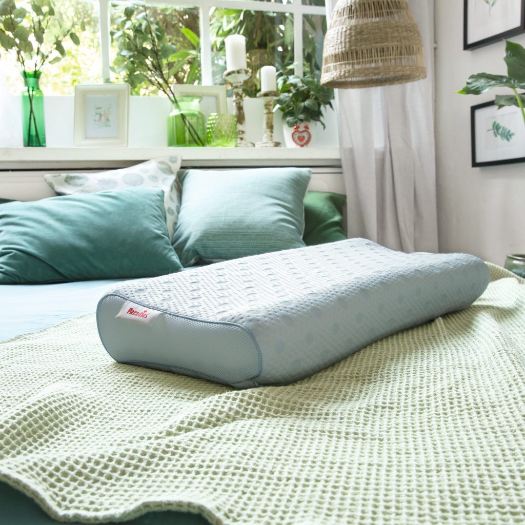 Paradies reVita Ergonomic Nackenstützkissen auf einem Bett im Schlafzimmer