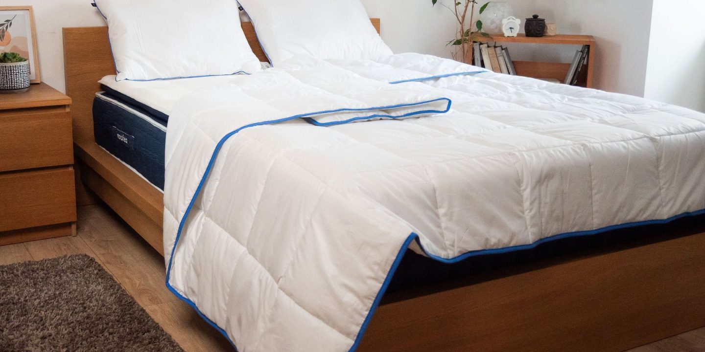 Gemachtes Bett mit weißer Bettdecke und zwei Kopfkissen