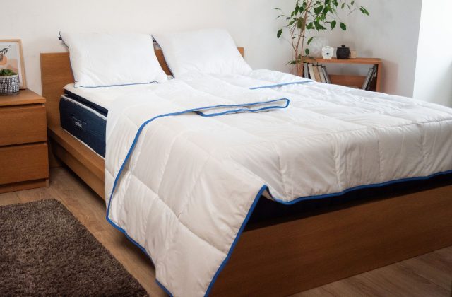 Gemachtes Bett mit weißer Bettdecke und zwei Kopfkissen