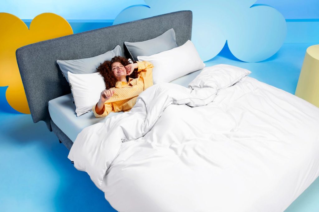 Frau liegt im Bett mit dem weißen Cloudpillo Bettwäsche-Set