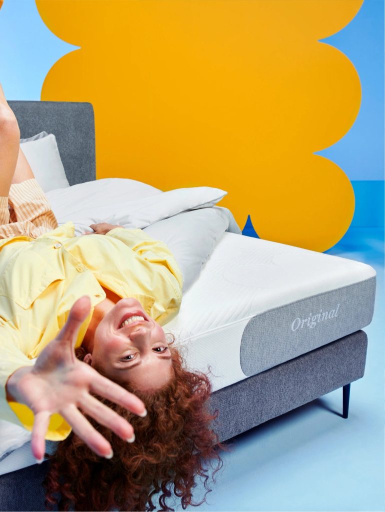Frau liegt lachend rücklings auf der Cloudpillo Original Matratze