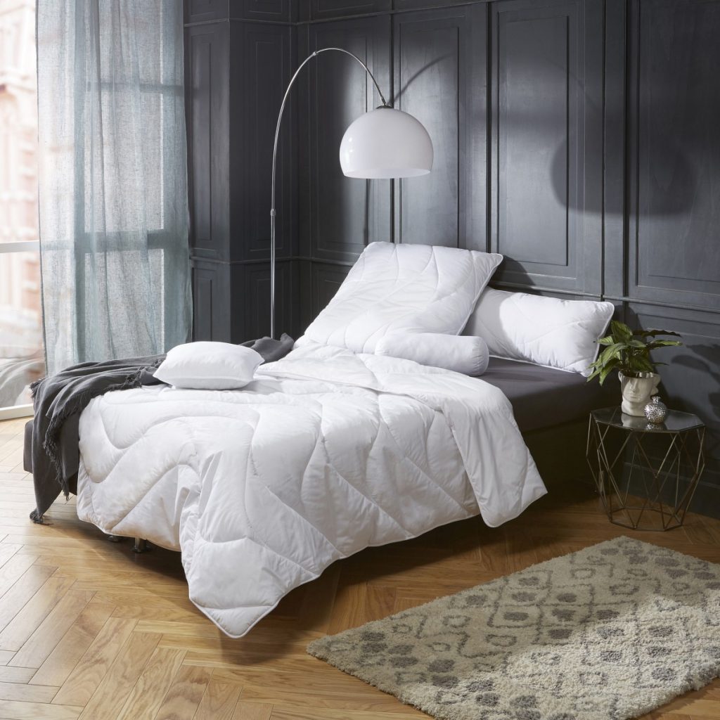 Erwin Müller Kissen Lech mit passender Steppdecke auf einem Bett im Schlafzimmer